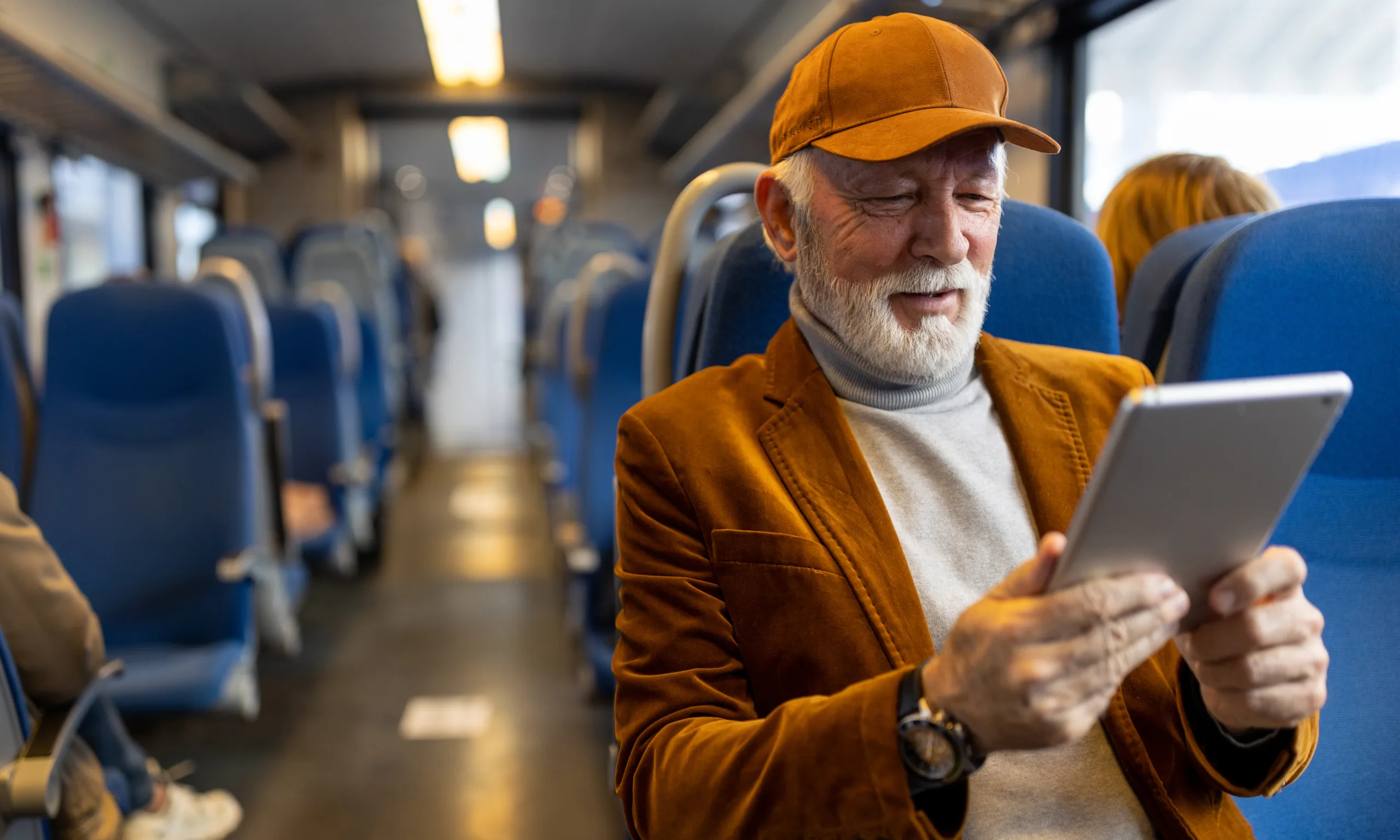 http://Senior%20man%20reading%20on%20tablet%20in%20train